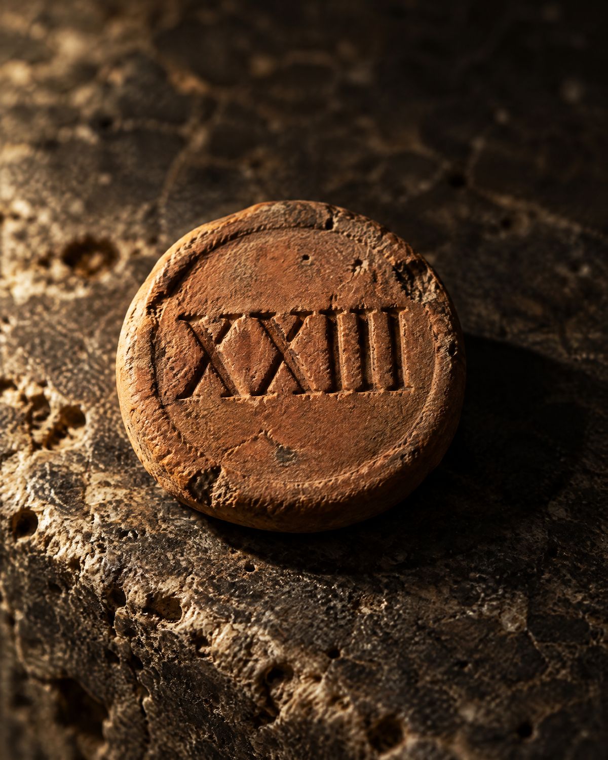 A clay entry token engraved with a Roman numeral